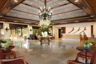 a large lobby with a chandelier and tables and chairs at AYANA Resort Bali in Jimbaran