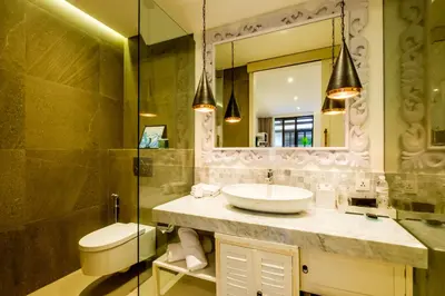 a bathroom with a sink and a toilet and a mirror at The Akasha Seminyak Bali Boutique Hotel in Seminyak