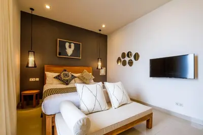 a bedroom with a bed and a couch at The Akasha Seminyak Bali Boutique Hotel in Seminyak