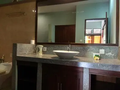 a bathroom counter with a sink and a mirror at D'Kubu Legian in Legian