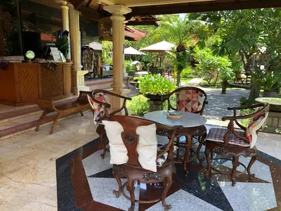 a wooden table and chairs on a patio at D'Kubu Legian in Legian