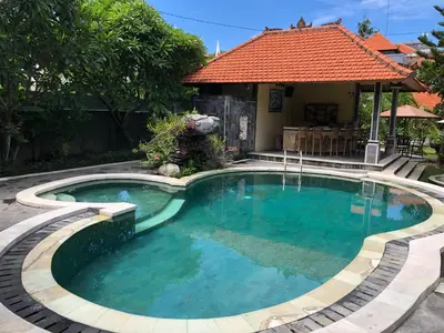 a swimming pool in front of a house at D'Kubu Legian in Legian
