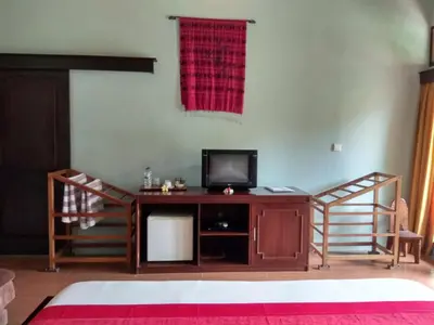 a living room with a tv on a wooden desk at D'Kubu Legian in Legian