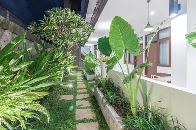 a garden in an office building with plants at Kak Garden Inn in Kuta