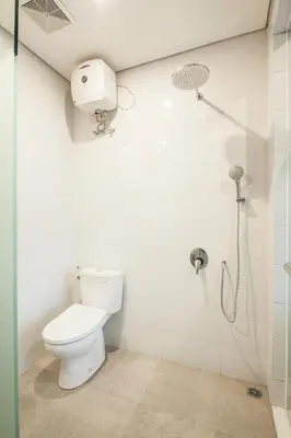 a bathroom with a toilet and a shower at Eclipse Kerobokan in Kerobokan