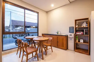 a kitchen with a table and chairs and a window at Eclipse Kerobokan in Kerobokan