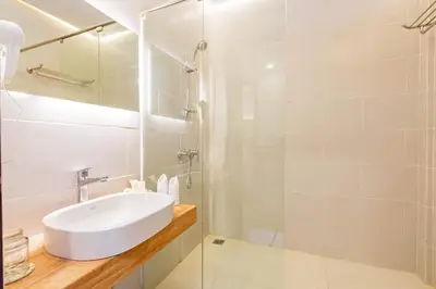 a white bathroom with a sink and a shower at Kashantee Village in Seminyak