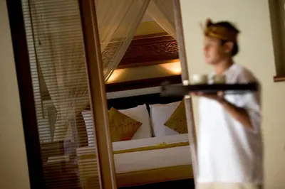 a man standing in front of a mirror in a bedroom at The Kunja Villa-Hotel in Seminyak