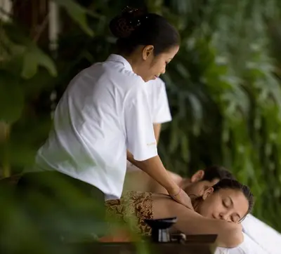 a woman getting a massage from a spa employee at The Kunja Villa-Hotel in Seminyak