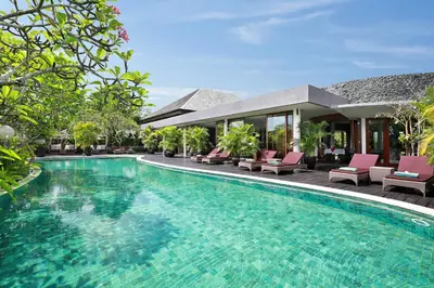 a swimming pool in front of a villa at Gending Kedis Luxury Villas & Spa Estate in Jimbaran