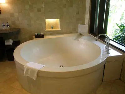a large bath tub in a bathroom with a window at Gending Kedis Luxury Villas & Spa Estate in Jimbaran