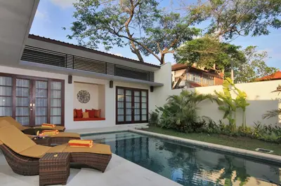 a villa with a swimming pool and a house at Destiny Villas and Residence in Seminyak