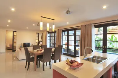 a kitchen and living room with a table and chairs at Destiny Villas and Residence in Seminyak