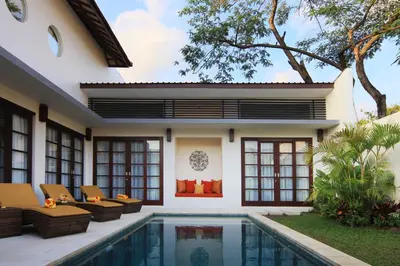 a house with a swimming pool in front of it at Destiny Villas and Residence in Seminyak