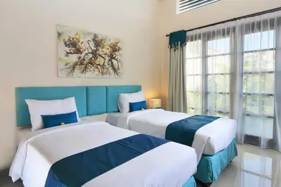 a bedroom with two beds and a window at Destiny Villas and Residence in Seminyak
