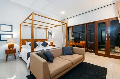 a bedroom with a bed and a couch in a room at MAHAYANA VILLA - 7Min Beach Access - 10min to Canggu in Canggu