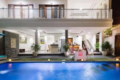 a villa with a swimming pool and a living room at Kubu Benoa Guest House in Nusa Dua