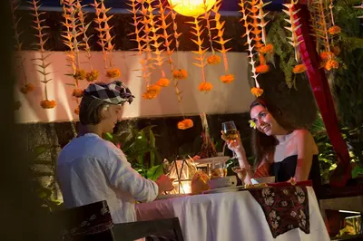 a man and a woman sitting at a table with wine glasses at Berry Amour Romantic Villas in Seminyak