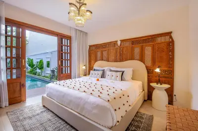a bedroom with a large bed and a pool at Villa Casa Adeline in Canggu