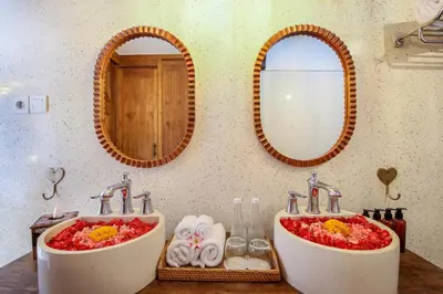 two sinks in a bathroom with two mirrors at Villa Casa Adeline in Canggu