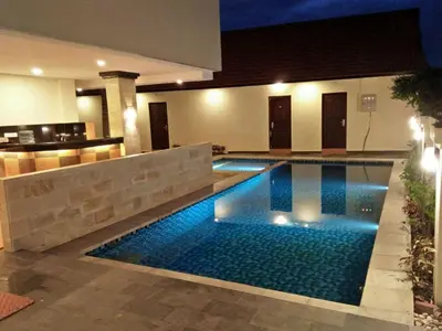 a swimming pool in the middle of a house at Familytel Bali in Jimbaran