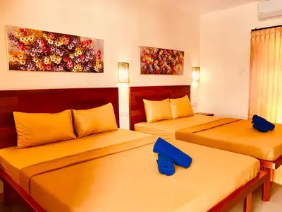 two beds in a room with two blue pillows at Familytel Bali in Jimbaran