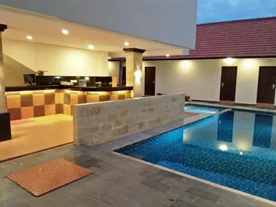 a swimming pool in the middle of a house at Familytel Bali in Jimbaran