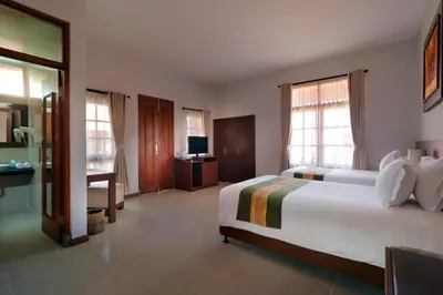 a hotel room with a bed and a television at Adi Dharma Hotel Legian in Legian