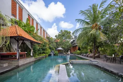 a swimming pool in front of a building at Adi Dharma Hotel Legian in Legian