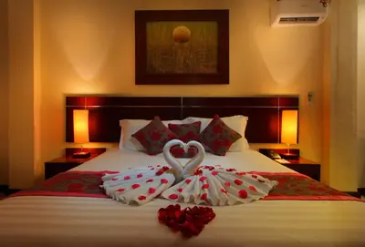 two heart shaped towels on a bed with roses at Adi Dharma Hotel Legian in Legian