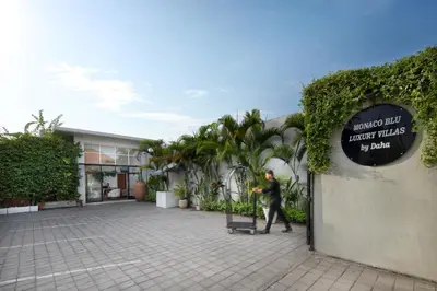 a man walking past a building with a sign at The Luxury Collection, Monaco Blu in Seminyak