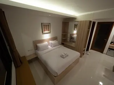a bedroom with a bed with two towels on it at Metta Agara in Kerobokan