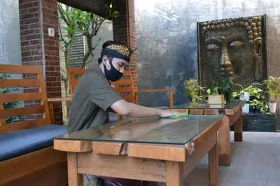 a man in a mask standing at a table at Metta Agara in Kerobokan