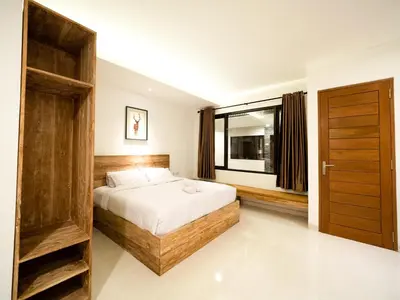 a bedroom with a bed and a large window at Metta Agara in Kerobokan