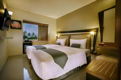 a hotel room with a large bed and a window at Hotel Neo - Kuta, Jelantik in Legian