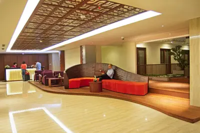 a man sitting on a bench in a lobby at Sense Sunset Hotel Seminyak in Seminyak