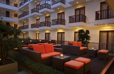 a hotel patio with couches and chairs in a building at Sense Sunset Hotel Seminyak in Seminyak