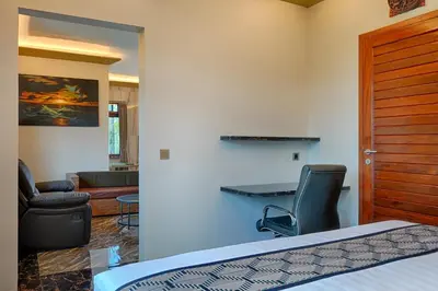 a bedroom with a bed and a desk and a chair at Kyara Villa Apartments in Canggu