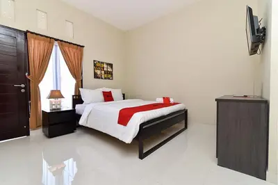 a bedroom with a bed and a television in it at RedDoorz Plus near Jalan Imam Bonjol Denpasar in Seminyak