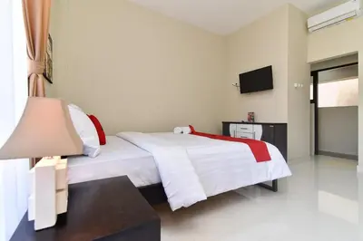 a hotel room with a bed and a television at RedDoorz Plus near Jalan Imam Bonjol Denpasar in Seminyak