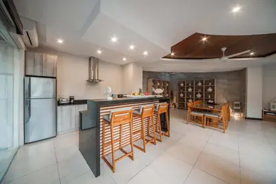 a kitchen with a counter and a dining room at Luxury Villa Juno Seminyak in Seminyak