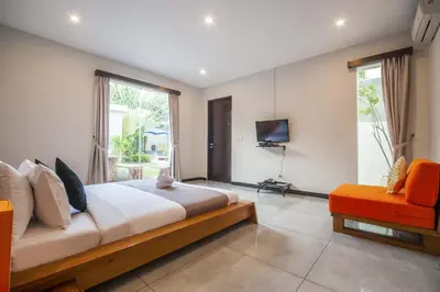a bedroom with a large bed and a television at Luxury Villa Juno Seminyak in Seminyak