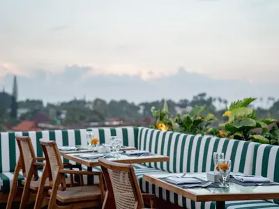 a row of tables and chairs on a patio at Cross Paasha Bali Seminyak in Seminyak