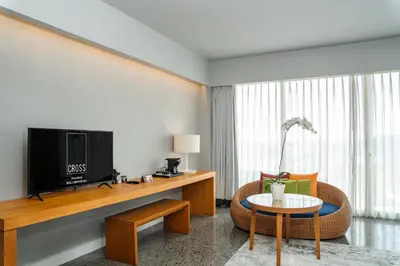 a living room with a television and a chair and a table at Cross Paasha Bali Seminyak in Seminyak