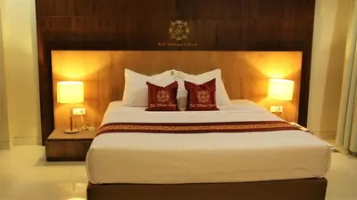 a bedroom with a large bed with red pillows at The Nibbana Villas in Seminyak