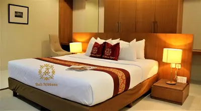 a large bed in a hotel room with two lamps at The Nibbana Villas in Seminyak