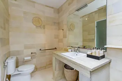 a bathroom with a sink and a toilet and a mirror at Villa Eindra Seminyak in Seminyak