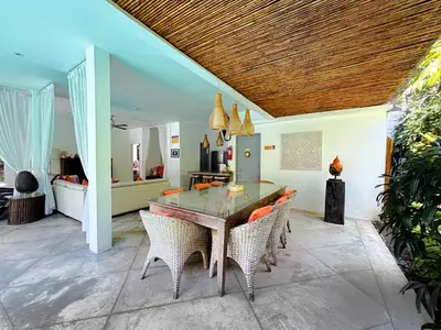 a dining room with a glass table and chairs at Villa Eindra Seminyak in Seminyak