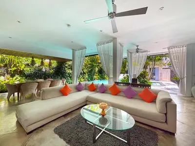 a living room with a couch and a glass table at Villa Eindra Seminyak in Seminyak