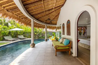 a villa with a swimming pool and a bedroom at Elina Villas Seminyak in Seminyak